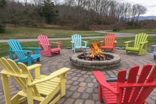 a group of colorful chairs around a fire pit at Carolina Motel in Franklin