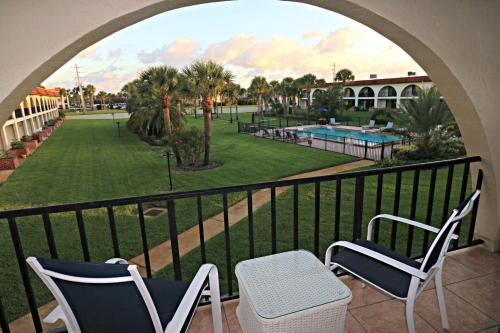 een balkon met 2 stoelen en een zwembad bij Ocean Club II Unit 19 in St. Augustine