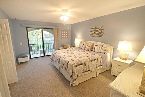 een slaapkamer met een bed en een groot raam bij Ocean Club II Unit 19 in St. Augustine