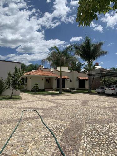 a house with a hose in front of a building at Villa Quinta Lomas casa completa con aéreas verdes in León