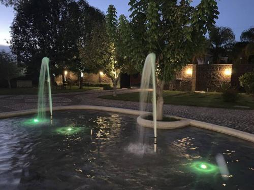 two water fountains in a pond at night at Villa Quinta Lomas casa completa con aéreas verdes in León