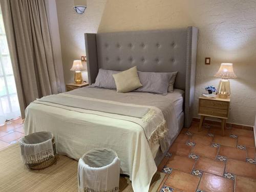 a bedroom with a large bed with two tables and two lamps at Villa Quinta Lomas casa completa con aéreas verdes in León