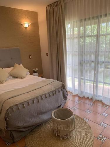 a bedroom with a bed and a large window at Villa Quinta Lomas casa completa con aéreas verdes in León