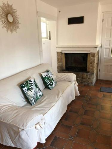 a white couch in a living room with a fireplace at Gîte Malgré tout in Aydius
