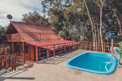 einem Pool vor einem Haus mit einem Gebäude in der Unterkunft Chalé incrível c/ piscina, Águas Mornas - SC in Aguas Mornas