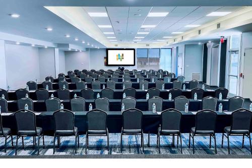 a conference room with a table and chairs and a screen at EVEN Hotel Omaha Downtown - Old Market by IHG in Omaha
