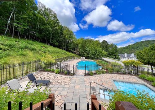 a backyard with a pool and a fence at Studio LIV203 by Gestion ELITE in Mont-Tremblant