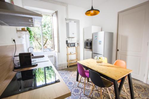 une cuisine avec une table, des chaises et un réfrigérateur dans l'établissement Le 62 - Spacieux T2 avec JARDIN, parking & tramway, à Grenoble
