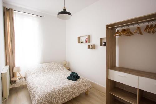 a bedroom with a bed with a teddy bear on it at Le 62 - Spacieux T2 avec JARDIN, parking & tramway in Grenoble