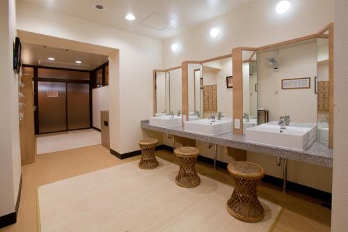 a bathroom with two sinks and two mirrors at Onsen Hotel Nakahara Bessou Nonsmoking, Earthquake retrofit in Kagoshima