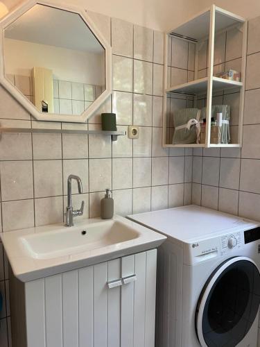 uma lavandaria com um lavatório e uma máquina de lavar roupa em West46 Apartment mit Netflix & Prime em Duisburgo