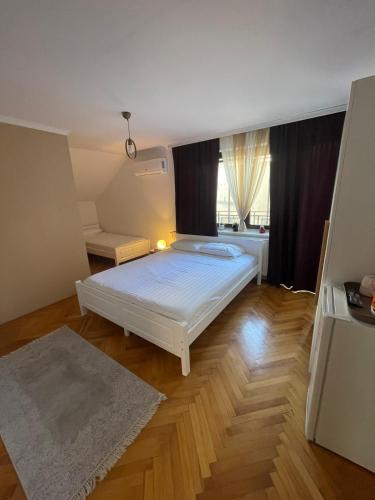 a small bedroom with a white bed and a window at Guesthouse 12a in Pristina