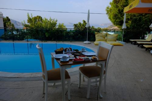 a table and chairs sitting next to a pool at Enda Boutique Hotel Kalkan in Kalkan