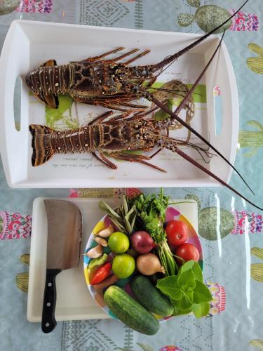 a plate of food with a lobster and a plate of vegetables at La Maison du Pécheur 97280 vous propose 2 bungalow, 2 Piscine privé avec jaccuzi intégrés, a 5 min de la plage et 2 min du port de pêche in Le Vauclin