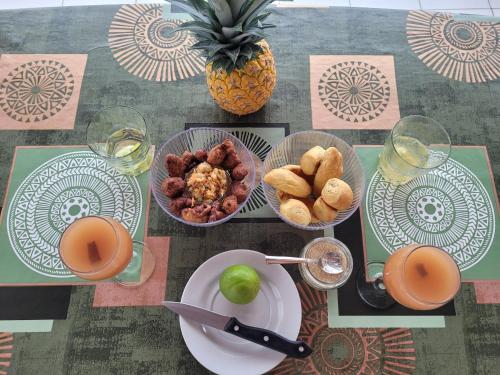 a table topped with plates of food and a pineapple at La Maison du Pécheur 97280 vous propose 2 bungalow, 2 Piscine privé avec jaccuzi intégrés, a 5 min de la plage et 2 min du port de pêche in Le Vauclin