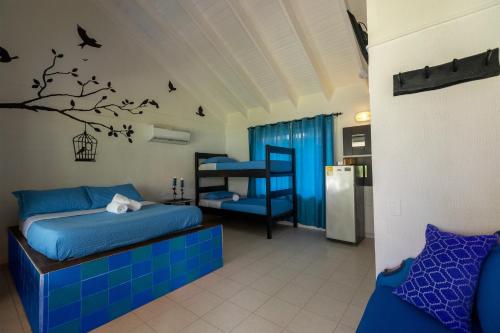 Un dormitorio con una cama y un árbol con pájaros. en Hosteria Mar y Sol en San Andrés