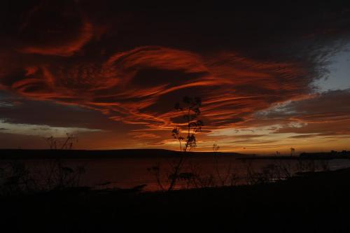 a sunset with a cloud formation in the sky at Eyri Seaside Houses in Hvammstangi