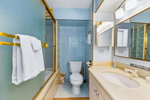 ein Badezimmer mit einem WC, einem Waschbecken und einem Spiegel in der Unterkunft Island Colony 3821 in Honolulu
