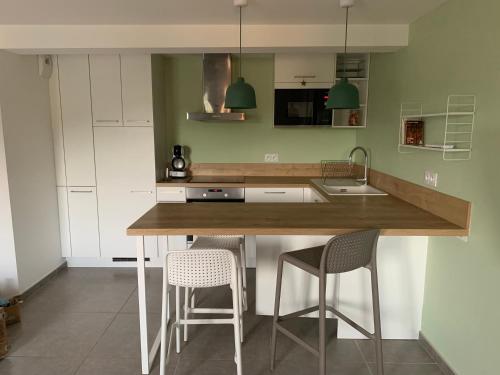 - une cuisine avec un comptoir, 2 chaises et un évier dans l'établissement Saint-Péray : La Chapelle du Prieuré, à Saint-Péray