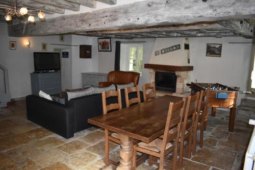 a living room with a wooden table and a fireplace at Le Moulin,19 bis rue de Beaudon, 45330 Augerville la riviere in Trézan
