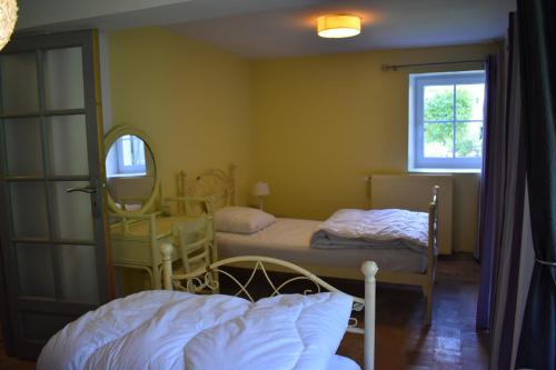 - une chambre avec 2 lits et un miroir dans l'établissement Le Moulin,19 bis rue de Beaudon, 45330 Augerville la riviere, à Trézan