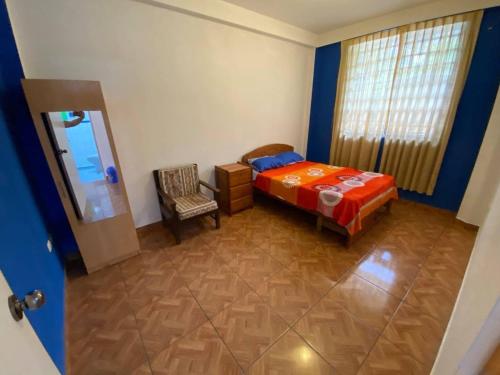 ein Schlafzimmer mit einem Bett, einem Stuhl und einem Spiegel in der Unterkunft Departamento amoblado Quillabamba in Quillabamba