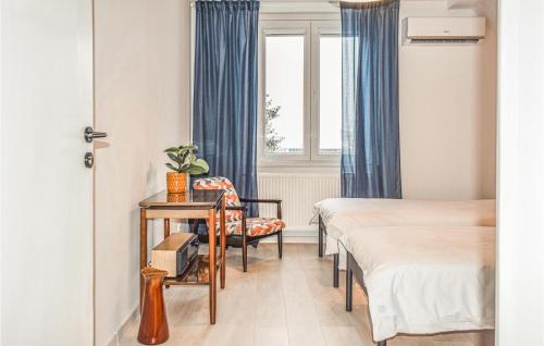 a room with two beds and a chair and a window at Awesome Apartment In Darlowo With Kitchen in Darłowo