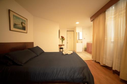 a bedroom with a large bed and a room with a hallway at Apartamentos Galerías in Bogotá