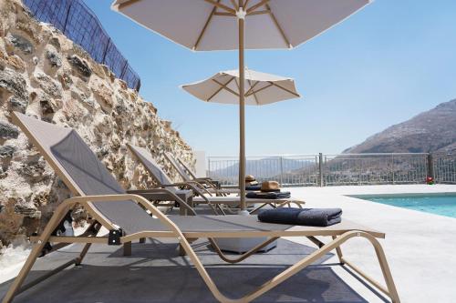 a group of chairs and umbrellas next to a pool at Villa Tzekos in Kendrokhórion