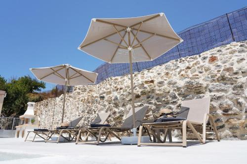 a group of chairs and umbrellas on a beach at Villa Tzekos in Kendrokhórion