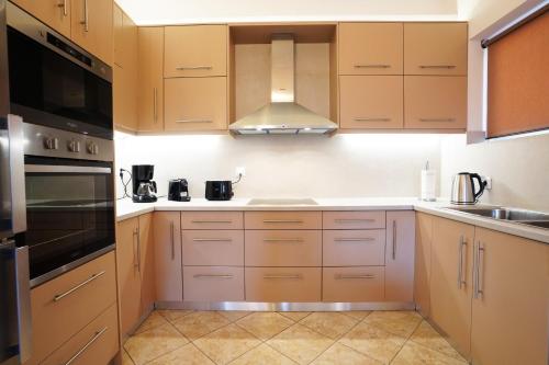 a kitchen with wooden cabinets and a stove top oven at Villa Tzekos in Kendrokhórion