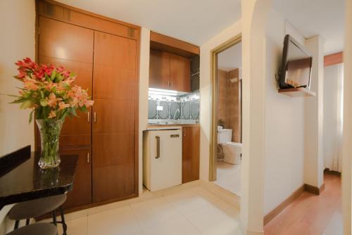 a kitchen with a vase of flowers on a table at Apartamentos Galerías in Bogotá