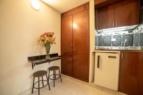 a kitchen with a vase of flowers on a counter at Apartamentos Galerías in Bogotá