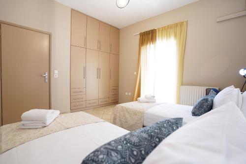 a hotel room with two beds and a window at Villa Tzekos in Kendrokhórion