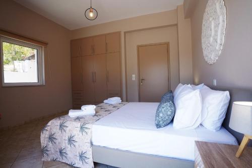 a bedroom with a large bed with white sheets and pillows at Villa Tzekos in Kendrokhórion