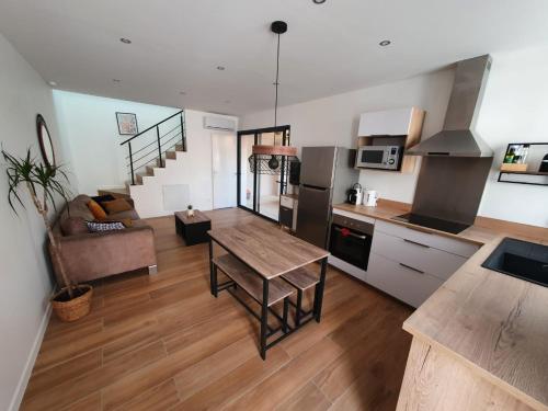 a kitchen and living room with a table and a couch at Villa l'Eden de Camargue- Spa et Nature in Candillargues