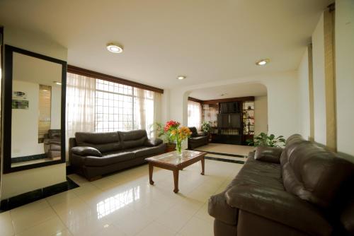 una sala de estar con sofás y una mesa con flores. en Apartamentos Galerías, en Bogotá