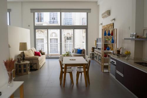a kitchen and living room with a table and chairs at Vivaterra Apartments - San Telmo in Buenos Aires