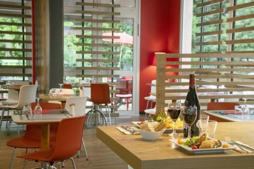 a table with a plate of food and a bottle of wine at ibis Gap Centre in Gap