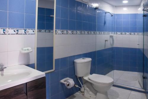 W wyłożonej niebieskimi kafelkami łazience znajduje się toaleta i umywalka. w obiekcie Apartamento tranquilo con hermosas vistas w mieście Cartagena de Indias