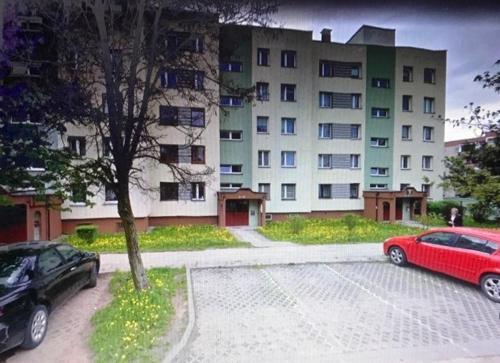 a red car parked in a parking lot in front of a building at Mieszkanie Osiedle Slichowice, Targi Kielce 3,5km, faktury VAT in Kielce