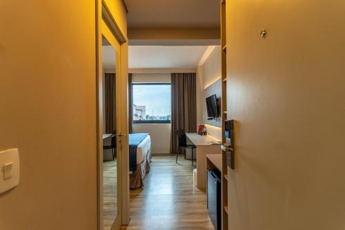 a hotel room with a bed and a window at Hotel Contemporâneo - Royal Palm Hotels & Resorts in Campinas