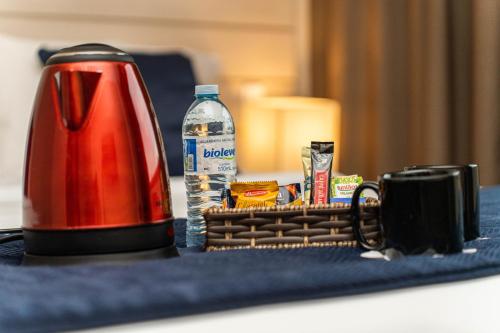 a red kettle and a cup of coffee and a bottle of water at Hotel Contemporâneo - Royal Palm Hotels & Resorts in Campinas