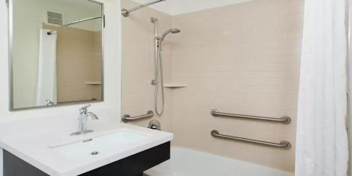 a white bathroom with a sink and a shower at MainStay Suites- Kansas City Overland Park in Overland Park