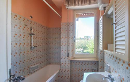 uma casa de banho com uma banheira, um lavatório e uma janela em Pet Friendly Apartment In Marcelli With Kitchen em Marcelli