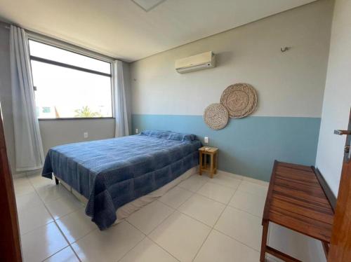 a bedroom with a blue bed and a window at Chalés Alegria e Estrela, Chaleville Maramar - Conforto, comodidade e internet, pertinho do mar! in Luis Correia