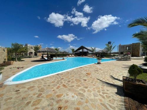 a large swimming pool in the middle of a resort at Chalés Alegria e Estrela, Chaleville Maramar - Conforto, comodidade e internet, pertinho do mar! in Luis Correia