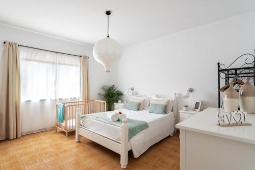 een witte slaapkamer met een bed en een raam bij Monte Madalena in Adega