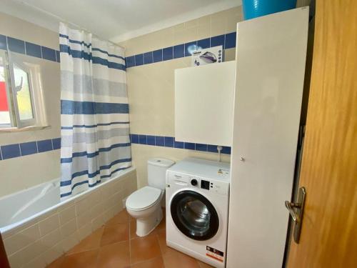 Un baño con inodoro y lavadora. en Tavira, en Tavira