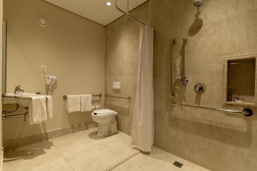uma casa de banho com um chuveiro, um WC e um lavatório. em Hotel Contemporâneo - Royal Palm Hotels & Resorts em Campinas